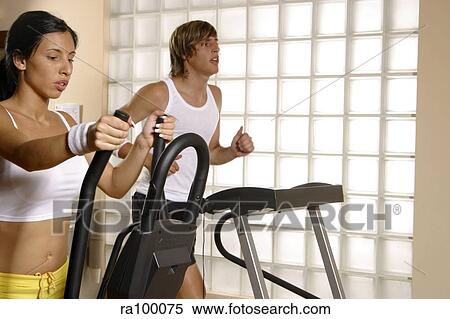 Two people on exercise bikes View Large Photo Image Stock Photography - Two people on exercise bikes. Fotosearch