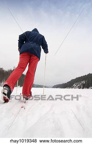 A cross country skier out on a refreshing trip over a frozen lake. View Large Photo Image Stock Photo - A cross country skier out on a refreshing trip over a frozen lake.. Fotosearch