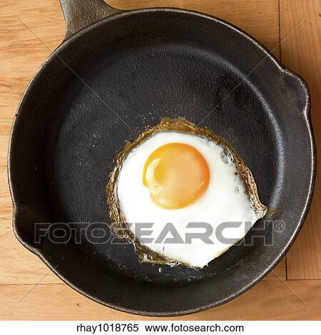 Stock Photography - A fried in a cast iron pan.. Fotosearch
