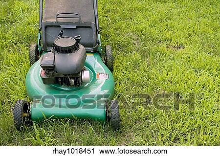 Stock Image - A modern lawn mower cutting through the grass.. Fotosearch