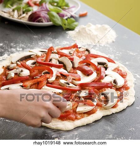 A young female making an italian style pizza at home in her apartment kitchen. View Large Photo Image Stock Photo - A young female making an italian style pizza at home in her apartment kitchen.. Fotosearch