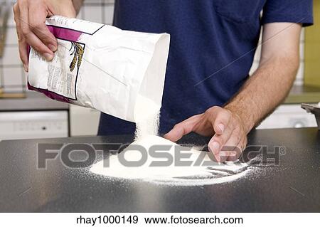 Stock Photo - A young man making pasta at home in an apartment kitchen.. Fotosearch