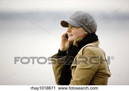 A young woman talking on a cell phone in winter. View Large Photo Image Stock Image - A young woman talking on a cell phone in winter.. Fotosearch