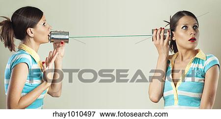 a young woman talking to herself on the tin can phone View Large Photo Image Stock Photo - a young woman talking to herself on the tin can phone. Fotosearch