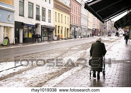 An old woman walking outdoors in the winter with a few snow crystals visible in the air. - Focus is on the woman with the background thrown out of focus. View Large Photo Image Stock Photo - An old woman walking outdoors in the winter with a few snow crystals visible in the air. - Focus is on the woman with the background thrown out of focus.. Fotosearch