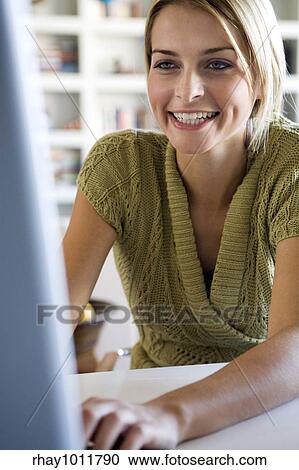 Stock Image - attractive blond woman working from home. Fotosearch
