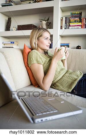 Stock Image - attractive blond woman working from home. Fotosearch