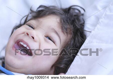 Beautiful baby boy smiling on bed View Large Photo Image Picture - Beautiful baby boy smiling on bed. Fotosearch