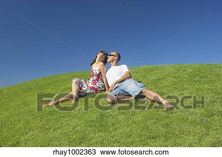 Beautiful couple of boyfriends relaxing on a beautiful green field View Large Photo Image Stock Image - Beautiful couple of boyfriends relaxing on a beautiful green field. Fotosearch