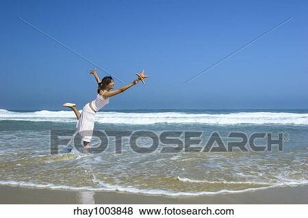 Beautiful woman feeling the breeze with a starfish on the hand View Large Photo Image Stock Photo - Beautiful woman feeling the breeze with a starfish on the hand. Fotosearch