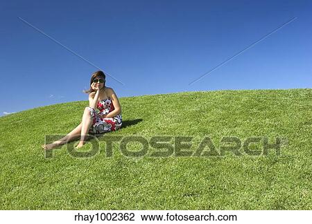 Beautiful woman relaxing on a beautiful green field View Large Photo Image Stock Image - Beautiful woman relaxing on a beautiful green field. Fotosearch