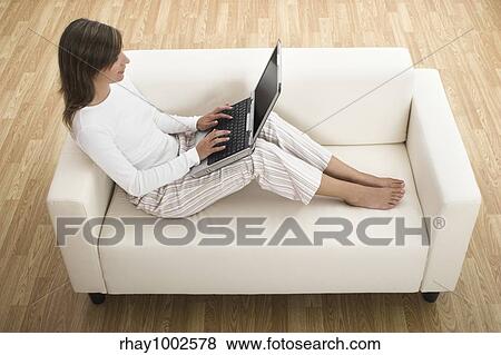 Stock Photo - Beautiful woman working at home with her laptop. Fotosearch