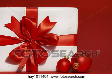 Big red bow on gift with red background and christmas balls View Large Photo Image Picture - Big red bow on gift with red background and christmas balls. Fotosearch