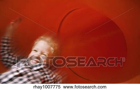 Boy slides down an red tube slide with motion blur. View Large Photo Image Stock Photography - Boy slides down an red tube slide with motion blur.. Fotosearch