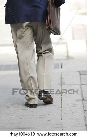 Stock Photo - Businessman walking on a busy street downtown. Fotosearch