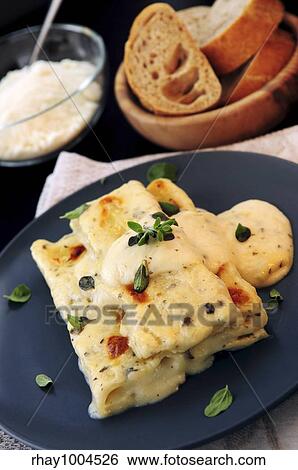 Stock Photograph - Cheese cannelloni pasta served on a plate with alfredo sauce. Fotosearch
