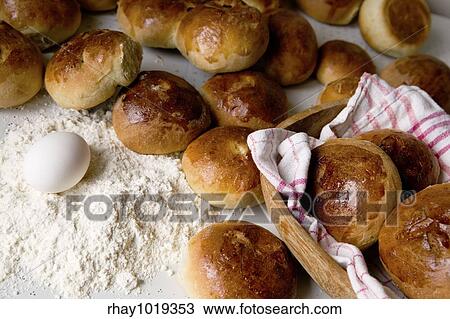 Stock Image - Close up detail of freshly baked hot cross buns in romantic renaissance lighting.. Fotosearch