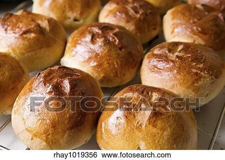 Stock Photograph - Close up detail of freshly baked hot cross buns in romantic renaissance lighting and a shallow depth of field.. Fotosearch