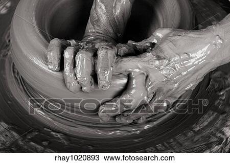 Stock Image - Close-up picture of a potter works a potter's wheel. Fotosearch