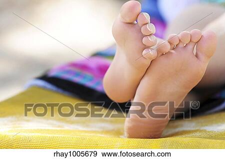 stock photograph of closeup of feet of a young girl in chaise lounge