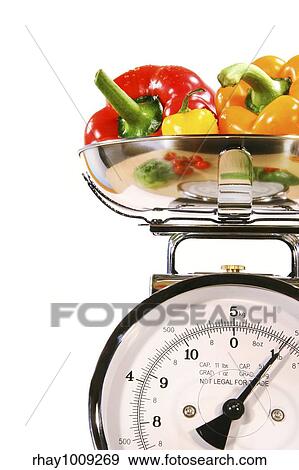 Stock Photo - Closeup of kitchen scale with colored peppers. Fotosearch