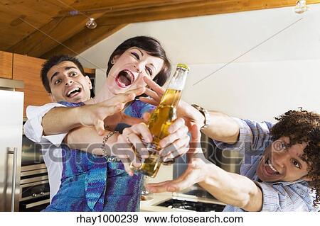 Stock Photo - domestic life: friends competing for the last beer. Fotosearch