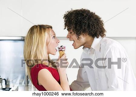 domestic life: interracial couple eating an ice cream View Large Photo Image Stock Photograph - domestic life: interracial couple eating an ice cream. Fotosearch