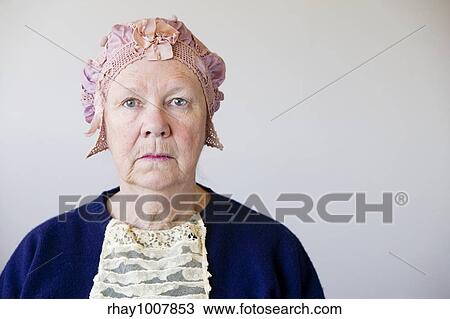 Dour senior woman in the studio wearing a vintage hat and lace. View Large Photo Image Stock Image - Dour senior woman in the studio wearing a vintage hat and lace.. Fotosearch