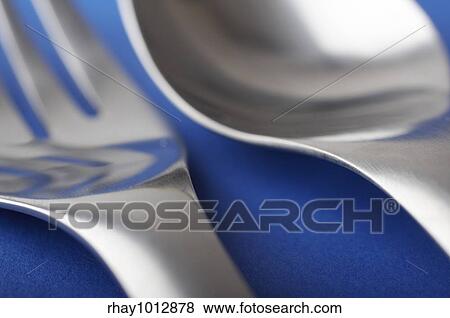Stock Photo - Fork and spoon on the blue table. Fotosearch