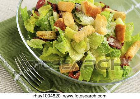 Stock Image - Fresh caesar salad served in a glass bowl. Fotosearch