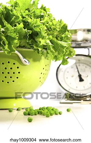 Picture - Fresh lettuce in strainer against white background. Fotosearch