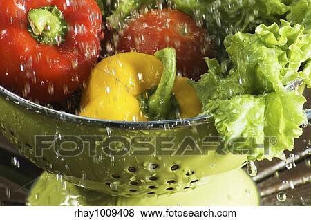 Stock Photo - frozen moment of vegetables being rinsed with water outside. Fotosearch
