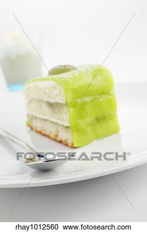 Stock Image - Green cake on the plate with frappucino on background. Fotosearch