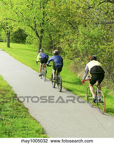 Group of friends bicycling in a summer park View Large Photo Image Stock Image - Group of friends bicycling in a summer park. Fotosearch