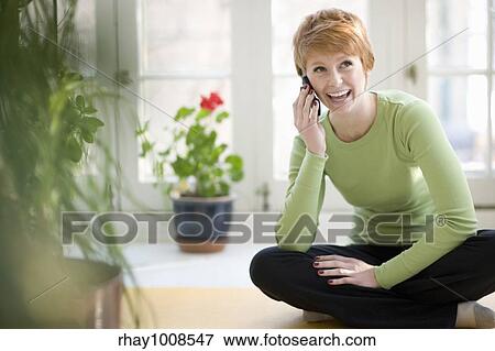 Happy young woman talking on a cell phone View Large Photo Image Stock Photo - Happy young woman talking on a cell phone. Fotosearch