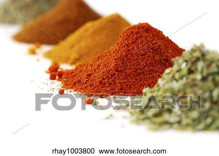 Stock Image - Heaps of various ground spices on white background. Fotosearch