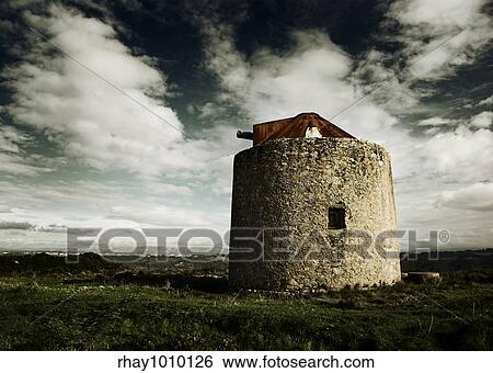 Stock Photograph - Landscape picture with an old vintage windmill - Colors adjusted in PS . Fotosearch