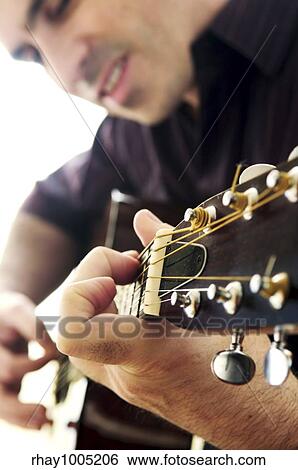 Man playing a musical instrument accoustic guitar View Large Photo Image Stock Photograph - Man playing a musical instrument accoustic guitar. Fotosearch