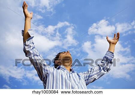 Picture - man praising the skies. Fotosearch