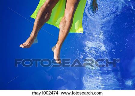 Picture - man's legs in pool. Fotosearch