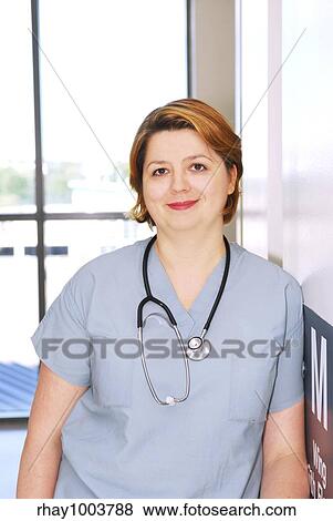 Portrait of a smiling nurse standing in a hospital corridor View Large Photo Image Stock Photo - Portrait of a smiling nurse standing in a hospital corridor. Fotosearch