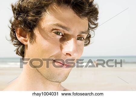 Stock Image - Portrait of a young man on the beach. Fotosearch