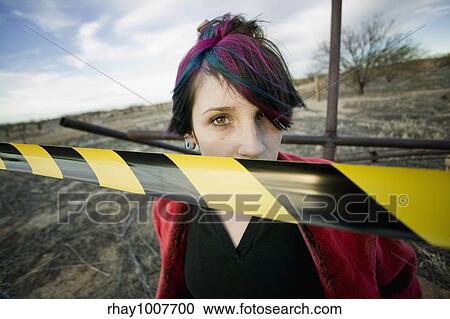 Punk girl outdoors behind a strip of yellow and black caution tape View Large Photo Image Stock Image - Punk girl outdoors behind a strip of yellow and black caution tape. Fotosearch