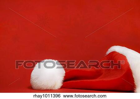 Red santa hat against a red background View Large Photo Image Stock Photograph - Red santa hat against a red background. Fotosearch