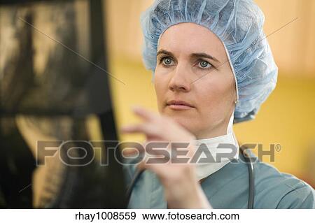 Stock Photo - Serious woman doctor analyzing X-rays. Fotosearch