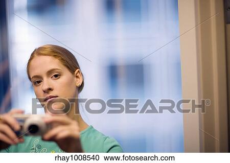Serious young woman taking pictures with digital camera View Large Photo Image Stock Image - Serious young woman taking pictures with digital camera. Fotosearch
