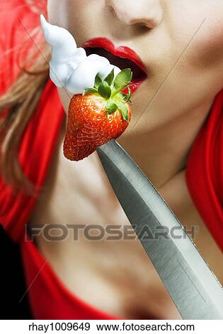 sexy woman in red eating strawberry with whipped cream from the knife blade View Large Photo Image Stock Photo - sexy woman in red eating strawberry with whipped cream from the knife blade. Fotosearch