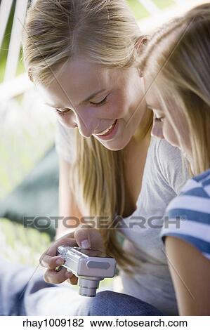Teenage girls looking at pictures on the back of a digital camera View Large Photo Image Stock Image - Teenage girls looking at pictures on the back of a digital camera. Fotosearch