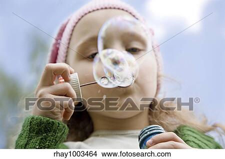 Picture - The little girl starts up soap bubbles close upThe little girl starts up soap bubbles close up. Fotosearch