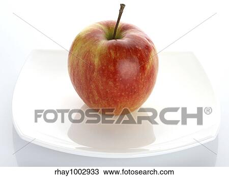 The ripe red apple lays on a white plateThe ripe red apple lays on a white plate View Large Photo Image Stock Image - The ripe red apple lays on a white plateThe ripe red apple lays on a white plate. Fotosearch
